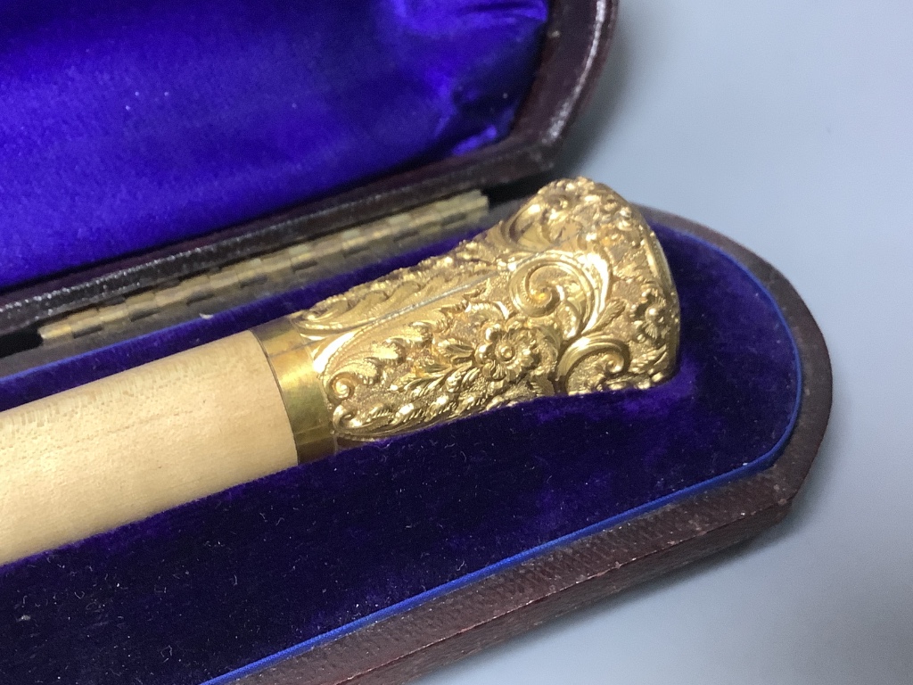 A yellow metal mounted conductor's baton, with monogram to handle base, in fitted case